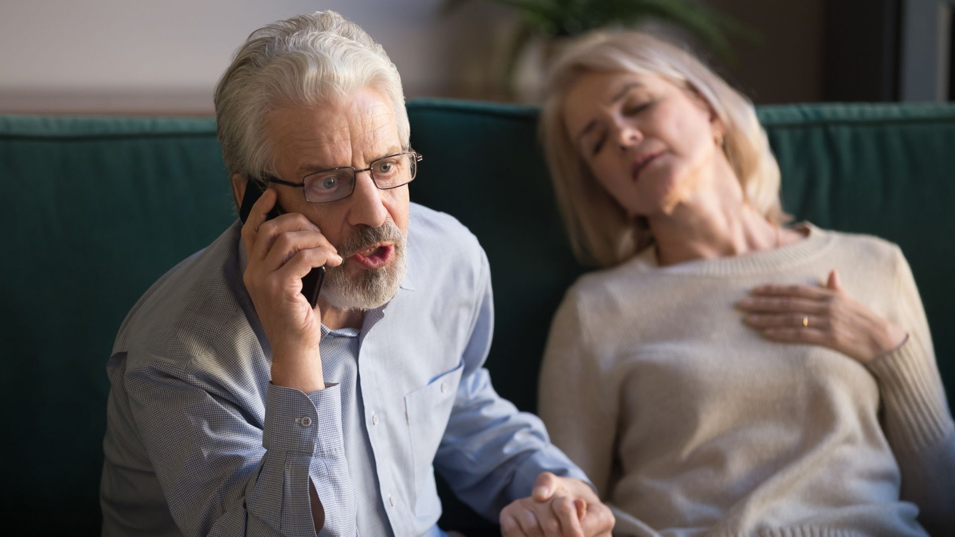 A man urgently calling 911 as his wife experiences chest pain, possibly indicating a heart attack