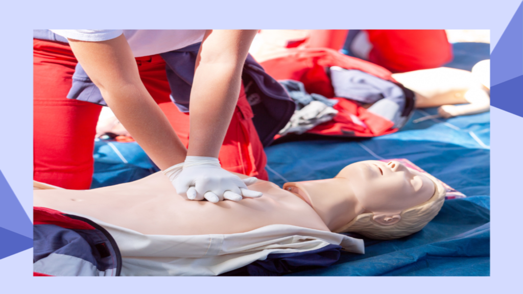 A person wearing white gloves performs CPR on a training mannequin lying on a blue mat. The mannequin is shirtless, and other equipment and mannequins are visible in the background.
