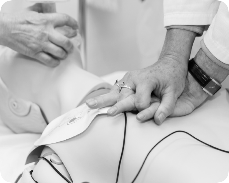 CPR Training Course - Close-up of instructor demonstrating chest compressions and AED pad placement on a CPR mannequin.