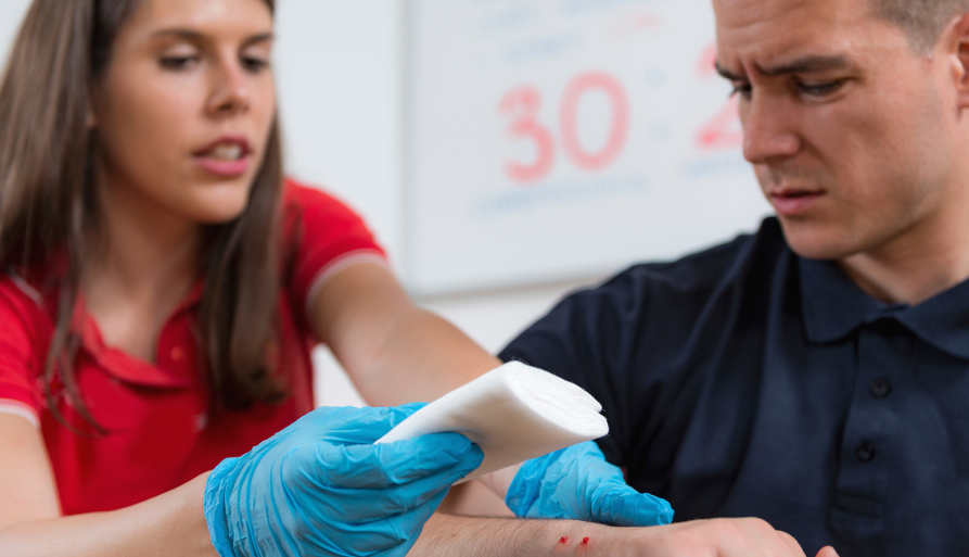 A PSW helping an injured person by bandaging.