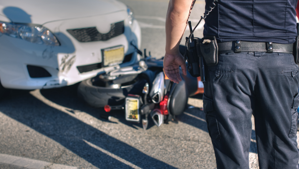 A police officer arriving at the place where a motorcycle accident took place.