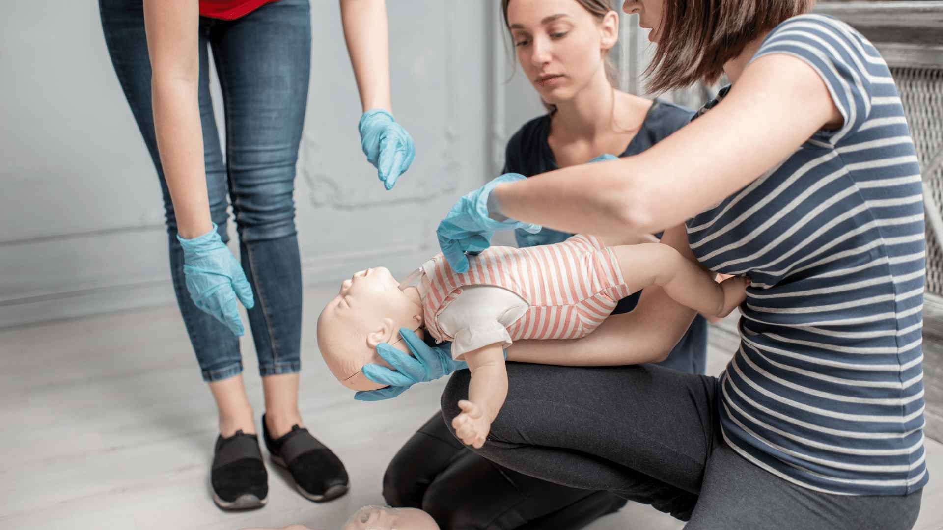 Person teaching how to perform CPR on a baby dummy