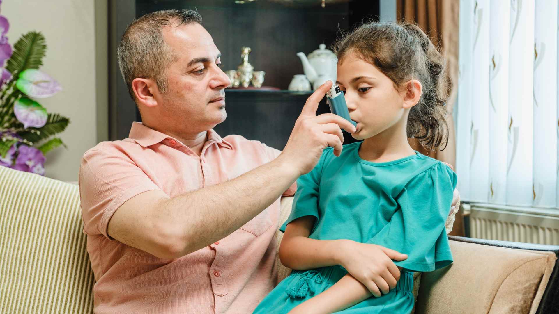 a parent helping his child with breathing problems.