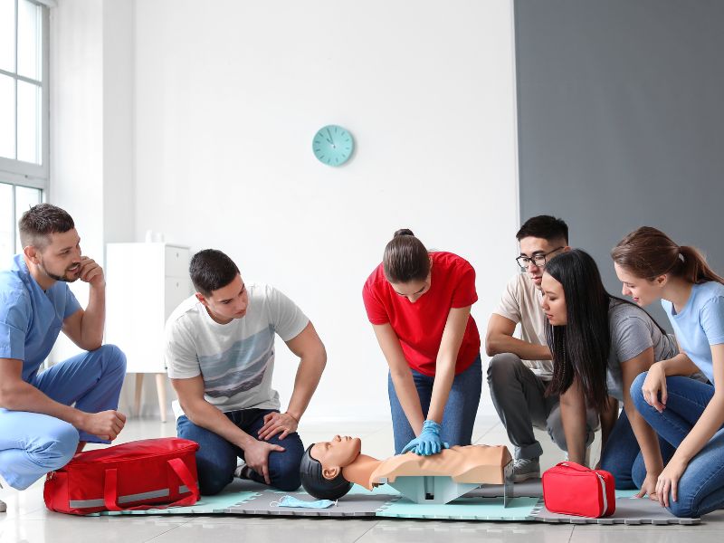 Close-up of AED device training during CPR certification course in California" SEO Rationale: Focuses on "AED training