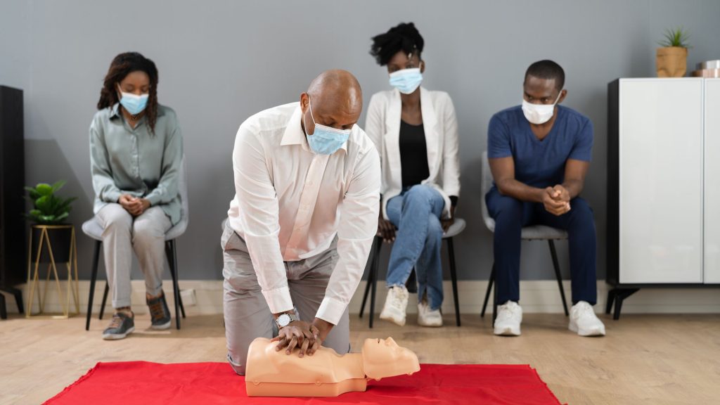 CPR practice session in California with instructor guiding students on mannequin techniques