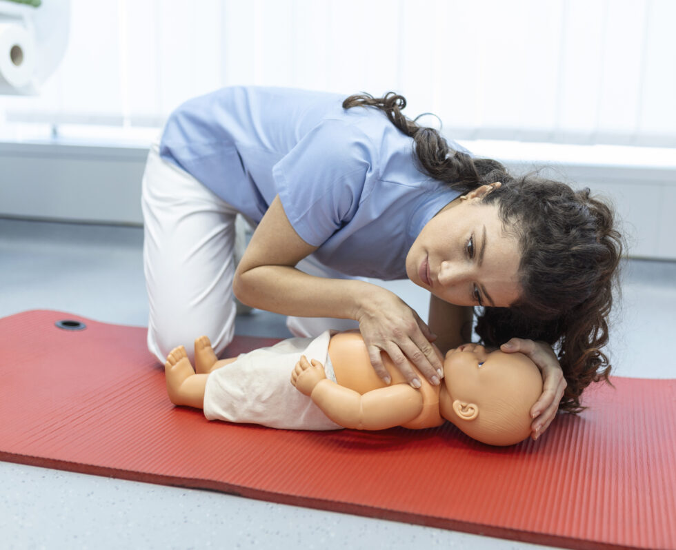 Parent practicing infant CPR techniques with baby mannequin in Vancouver Coast2Coast class