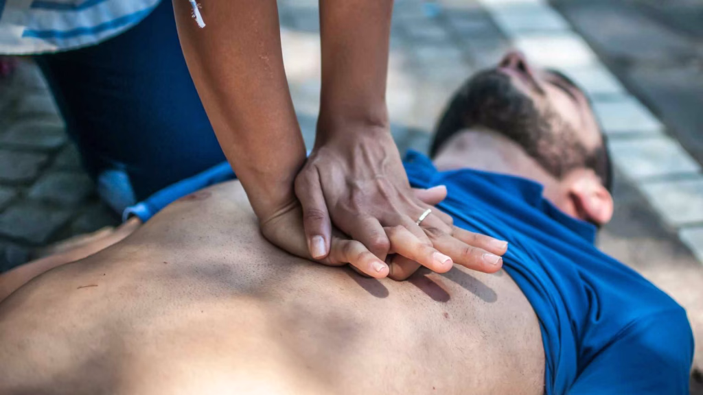 woman performing cpr on man