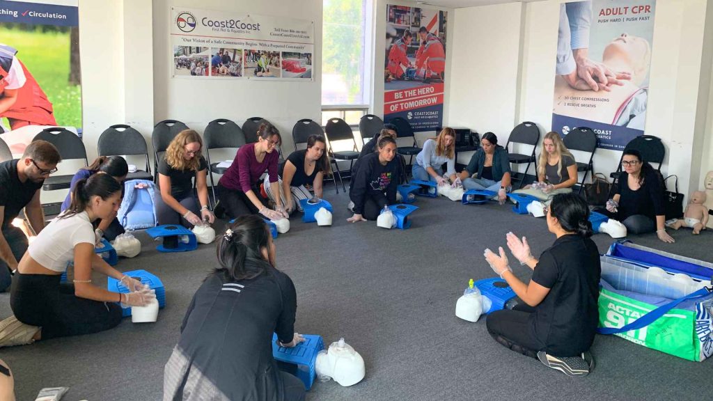 large group of coast2coast students practicing cpr in a training room