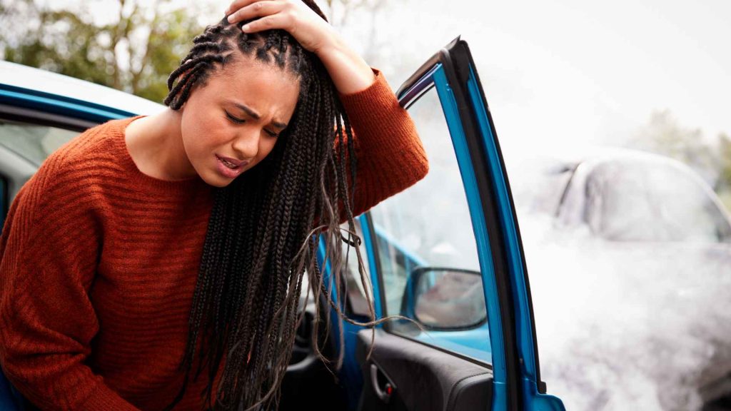 woman holding head after a car accident
