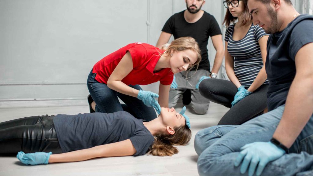 first aid and cpr training courses with instructor performing a head tilt chin lift on a participant