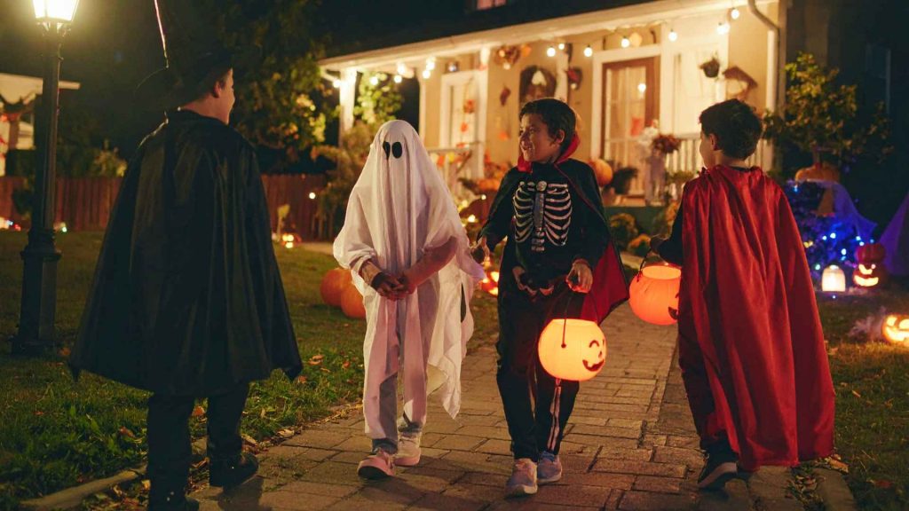 4 kids trick-or-treating in different costumes
