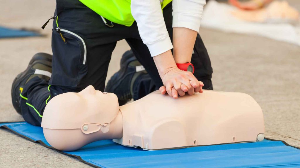 close up of someone practicing cpr on a cpr manikin