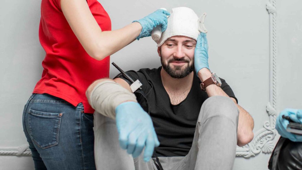 man getting his head wrapped as practice for head injuries in a first aid training course